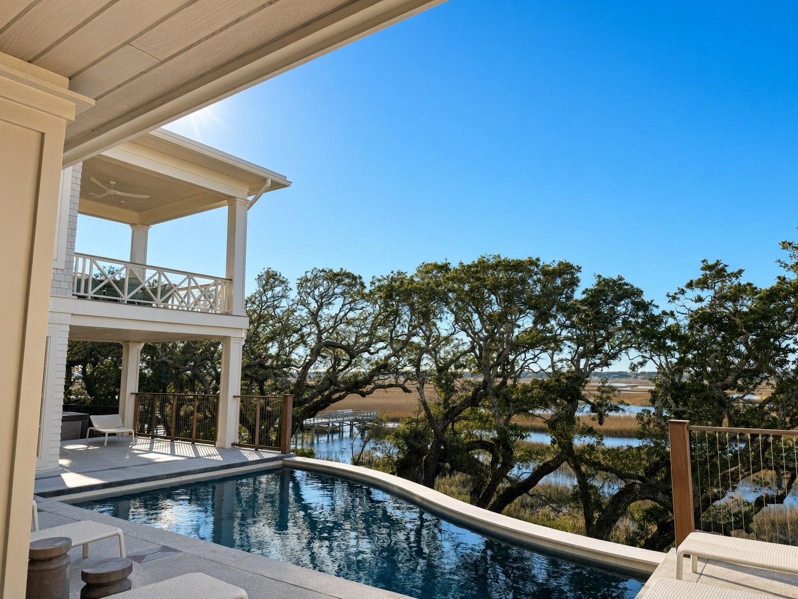 Heated pool and spa bordered by a covered terrace and live oaks