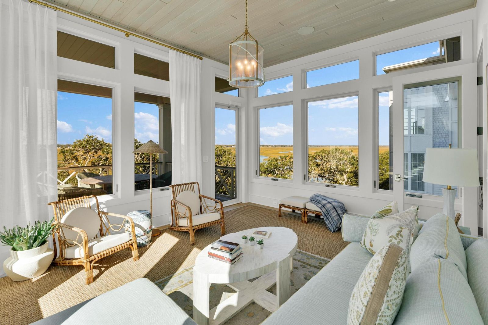 Sunroom with rattan chairs and marsh views